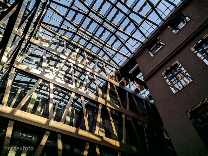 Naujosios dalies fasadas su perėjimu į stiklinį stogą, įleidžiantį daugybę saulės šviesos